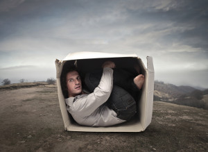 bigstock-Man-crouched-into-a-box-in-a-w-38591734